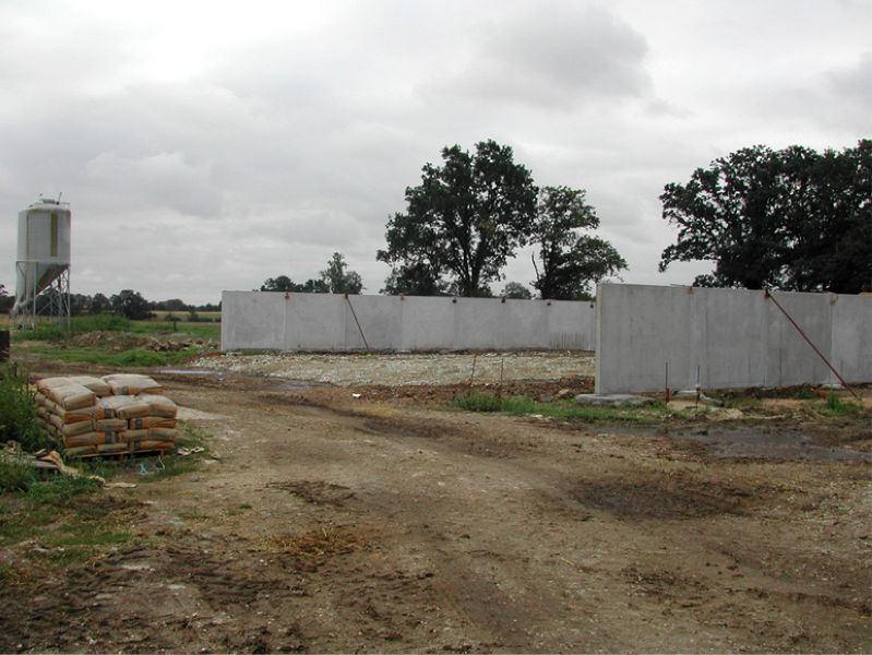 Plateforme terrassée et murs en béton d'un bâtiment agricole