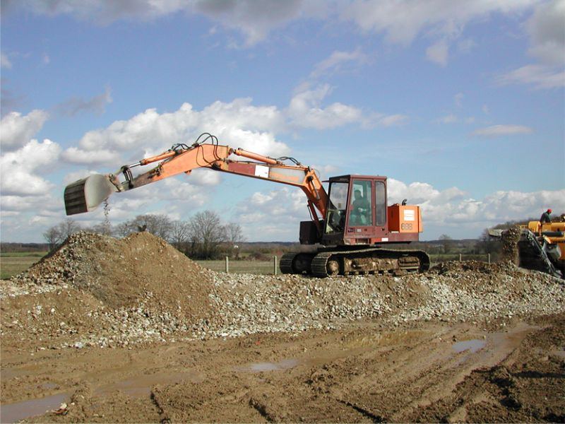 Pelle orange Hitachi sur un chantier de concassage de béton