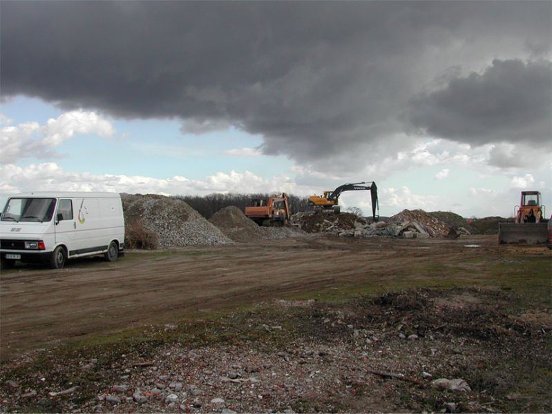 Site de concassage : tas de gravats, camionnette et pelle