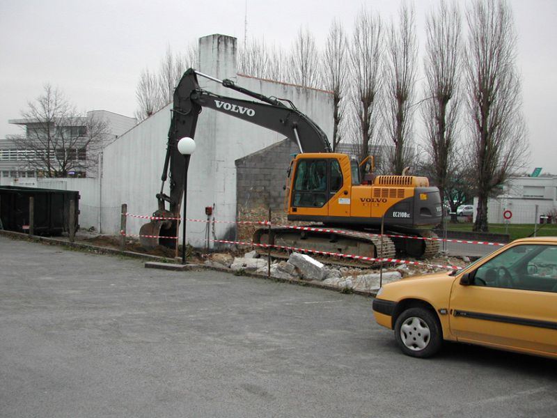 Pelle Volvo devant un bâtiment à déconstruire