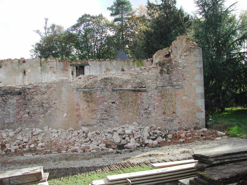Mur de pierre restant et gravats après une démolition